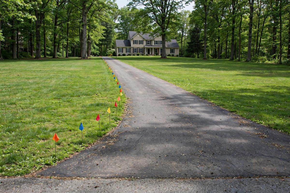 Long driveway with utility marking flags tracing a water line route in West Donegal Township near Elizabethtown